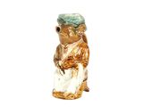 une figurine représentant une grenouille coiffée d'un chapeau