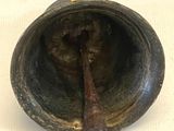 un petit objet en métal contenant une cuillère en bois