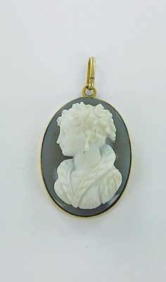 a close up of a white and black cameo pendant on a white background