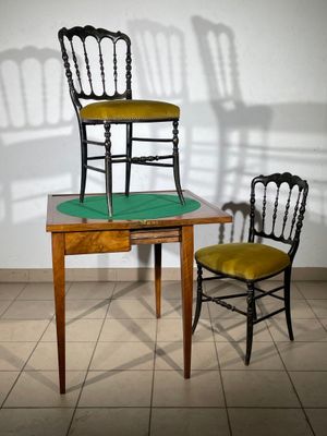 two chairs sitting next to a table with a chair on it