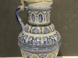 a blue and white vase with a handle on a table