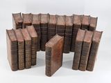 several old books stacked on top of each other on a white surface