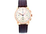 gros plan d'une montre sur fond blanc avec un bracelet marron