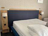 un lit avec des draps et des oreillers blancs dans une chambre