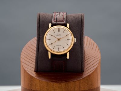 an image of a watch on a wooden stand with a grey background