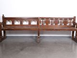 a wooden bench sitting in a room with a wall behind it