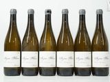 six bouteilles de vin sont alignées sur une table