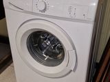 a white washing machine sitting on the floor in a room