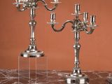 deux chandeliers en argent posés sur une table