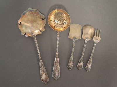 five silver spoons and five silver spoons on a table