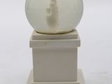 a snow globe sitting on top of a white pedestal