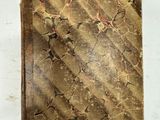 un vieux livre posé sur une table à côté d'une feuille de papier