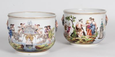 une paire de tasses en porcelaine ornées de personnages peints, posées sur une table