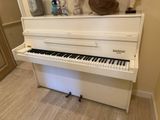 a white piano in the corner of a room