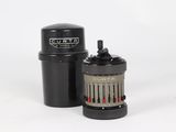 a close up of a camera lens and a canister on a white surface