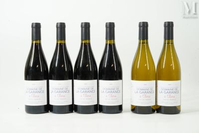 six bouteilles de vin sont alignées sur une surface blanche