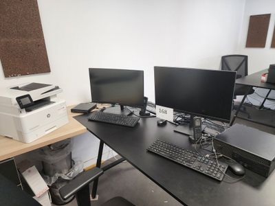 a desk with two computer monitors and a printer on it