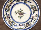l'image d'une assiette sur laquelle figurent un oiseau et des fleurs