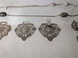 a lot of silver jewelry on display in a glass case