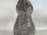 a gray vase that is sitting on a white surface