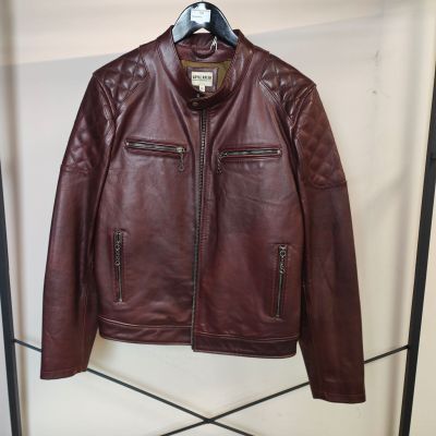 une veste en cuir marron suspendue à un porte-manteau dans une pièce