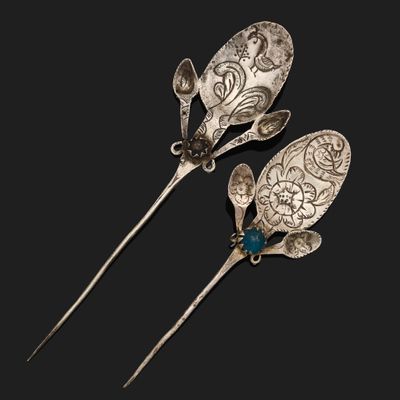 deux cuillères en argent ornées de pierres bleues sur fond noir