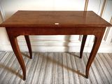 a small wooden table with a label on it