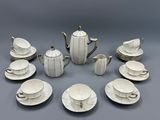 une photo montrant un ensemble d'assiettes et de tasses blanches posées sur une table