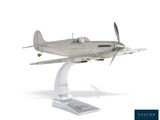 une maquette en argent représentant un petit avion, posée sur un socle