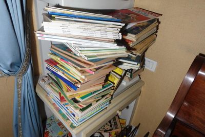 une pile de livres posée sur une étagère dans un coin de la pièce