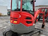 an image of a red and gray excavator parked in a parking lot