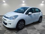 la petite voiture blanche est garée sur un carrelage à carreaux