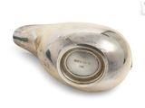 a silver shell with a clock in it on a white surface