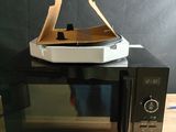 un micro-ondes sur lequel est posée une boîte à pizza