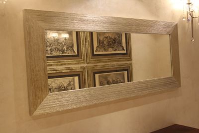 un miroir sur le mur au-dessus d'un lavabo dans une salle de bains