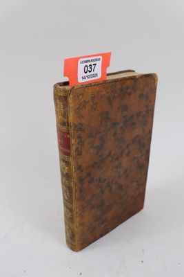 un vieux livre portant une étiquette rouge, posé sur une surface blanche