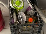 a basket full of dirty dishes and utensils on the floor