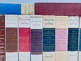 several books are lined up in a row on a white surface