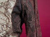 the back of a woman ' s dress with a lace pattern on it
