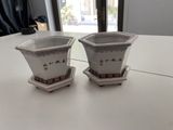 two cups sitting on a table with a window in the background