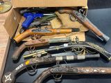 tout un tas d'armes à feu qui traînent dans une boîte