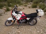 une moto blanche et rouge garée sur le bord de la route