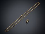 a gold necklace and a ring on a black background