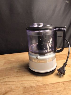un petit robot ménager posé sur une table, dont le cordon d'alimentation est branché