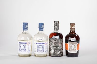 trois bouteilles d'alcool sont alignées sur une surface blanche