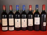 six bottles of red wine are lined up on a red table
