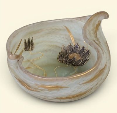 a glass bowl with a flower in it on a table
