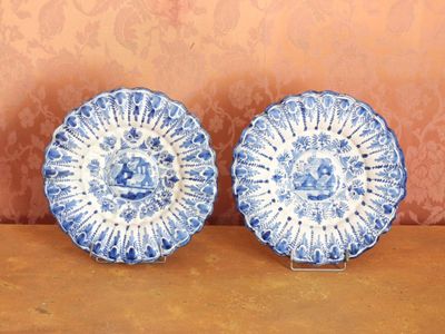 une paire d'assiettes bleues et blanches ornées de motifs, posées sur une table
