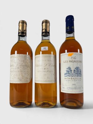 trois bouteilles de vin posées les unes à côté des autres sur une surface blanche