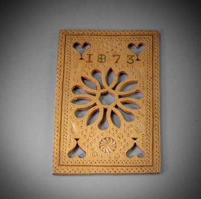 a wooden plaque with a flower design on it